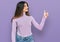 Young beautiful teen girl wearing turtleneck sweater looking proud, smiling doing thumbs up gesture to the side