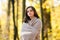 Young beautiful teenager girl surrounded autumn leaves outdoor.