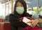 Young beautiful tourist Asian Chinese tourist girl at airport wearing protective facial mask checking internet news and