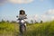 Young beautiful tourist or nomad traveler black afro American woman riding motorbike in tropical field wearing traditional Asian h