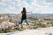 Young beautiful travel girl on top of a hill in Cappadocia, Turkey. She jumps up. Travel, success, freedom, achievement.