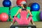 Young beautiful white girl in a pink sports suit with dumbbells sits on a step before training in a fitness club.