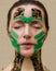 Young beautiful woman, 40 years old, Caucasian type, aesthetic taping procedure. The color of the ribbons is military style and