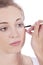 Young beautiful woman applying concealer on face