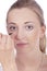 Young beautiful woman applying concealer on face