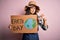 Young beautiful woman asking for planet conservation holding cardboard celebrating earth day with angry face, negative sign