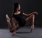 Young beautiful woman ballerina in black body suit posing over b