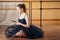 Young and beautiful woman in ballet dress and pointe looking to the phone and listening to music. The ballerina does