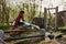 Young beautiful woman bird farm worker smiling and happy feeding chickens at the feeding trough outdoors sitting on the