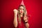 Young beautiful woman on birthday celebration over red isolated background annoyed and frustrated shouting with anger, crazy and