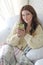 Young beautiful woman with blanket sitting by window