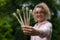 Young beautiful woman with blonde curly hair in pink hipster jacket and eyeglasses holding five bamboo toothbrushes in