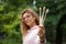 Young beautiful woman with blonde curly hair in pink hipster jacket and eyeglasses holding tree bamboo toothbrushes in