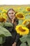 Young beautiful woman on blooming sunflower field in summer, health and lifestyle