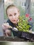 Young beautiful woman with a braid seedling petunia in boxes in the spring