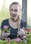 Young beautiful woman with a braid seedling petunia in boxes in the spring