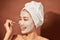 Young beautiful woman with clay mask on her face. Salon skin care, natural cream of algae