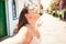 Young beautiful woman at the colorful village of Puerto de Mogan, smiling happy sunbathing with open arms on the street on summer