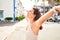 Young beautiful woman at the colorful village of Puerto de Mogan, smiling happy sunbathing with open arms on the street on summer