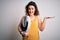Young beautiful woman with curly hair holding weighing machine and tape measure very happy and excited, winner expression