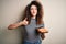 Young beautiful woman with curly hair and piercing holding tray with fresh sushi happy with big smile doing ok sign, thumb up with