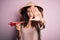 Young beautiful woman with curly hair and piercing wearing asian hat holding paper plane with open hand doing stop sign with