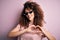 Young beautiful woman with curly hair and piercing wearing funny thug life sunglasses smiling in love showing heart symbol and