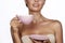 Young beautiful woman with dark hair picked up holding a ceramic cup and saucer pale pink drink tea or coffee on a white back