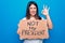 Young beautiful woman on disagreement holding banner with not my president message doing ok sign with fingers, smiling friendly