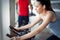 Young beautiful woman doing indoor biking exercise