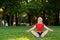 Young beautiful woman doing yoga sitting on the grass in the Park. training and stretching muscles in nature