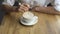 A young beautiful woman drinking coffee in a cafe. Hand of girl stiring sugar in coffee close up