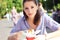 Young beautiful woman eating fast food noodles in st