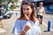 Young beautiful woman eating ice cream cone walking down the street of Tenerife on a sunny day of summer on holidays