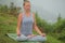 Young beautiful woman is engaged in hatha yoga in the morning misty mountains