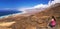 Young beautiful woman enjoying the view to Cofete sandy beach with vulcanic mountains in the background, Jandia, Fuerteventura, s