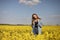 Young beautiful woman in a field with yellow blooming rapeseed. girl in yellow floral field, rapeseed plantation, summer vacation