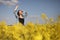 Young beautiful woman in a field with yellow blooming rapeseed. girl in yellow floral field, rapeseed plantation, summer vacation