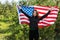 A young beautiful woman with a flag of the United States of America