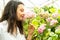 young beautiful woman gardener sniffs hydrangea flowers in greenhouse.