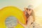 Young beautiful woman in glasses and hat holding an orange swimming circle. The concept of holiday resort and travel