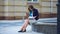 Young beautiful woman with glasses reading a book in the city