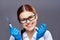 Young beautiful woman on a gray background in rubber gloves holds a syringe, doctor, medicine, hospital