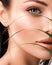 Young beautiful woman with green leaves near face. Skin care beauty treatments concept.  Closeup girl`s face with green leave