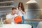 Young beautiful woman greeting her surprised husband with present in red bag on saint valentine`s day during breakfast in the