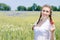 Young beautiful woman happy smiling & looking at camera in green wheet field on summer day