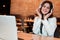 Young beautiful woman in headphones listening her favourite music from laptop while waiting her lunch in the cafe happy weekdays