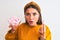 Young beautiful woman holding bowl with marshmallows over isolated white background scared in shock with a surprise face, afraid