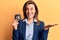 Young beautiful woman holding detective badge celebrating victory with happy smile and winner expression with raised hands