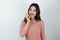 Young beautiful woman holding fresh banana like a phone looking happy being on diet isolated white background